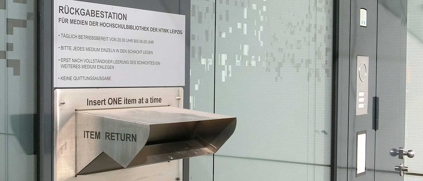 Rückgabeautomat (Rückseite Hochschulbibliothek) Die Rückgabestation mit Einwurfschlitz ist beschriftet und befindet sich an der Rückseite der Hochschulbibliothek.